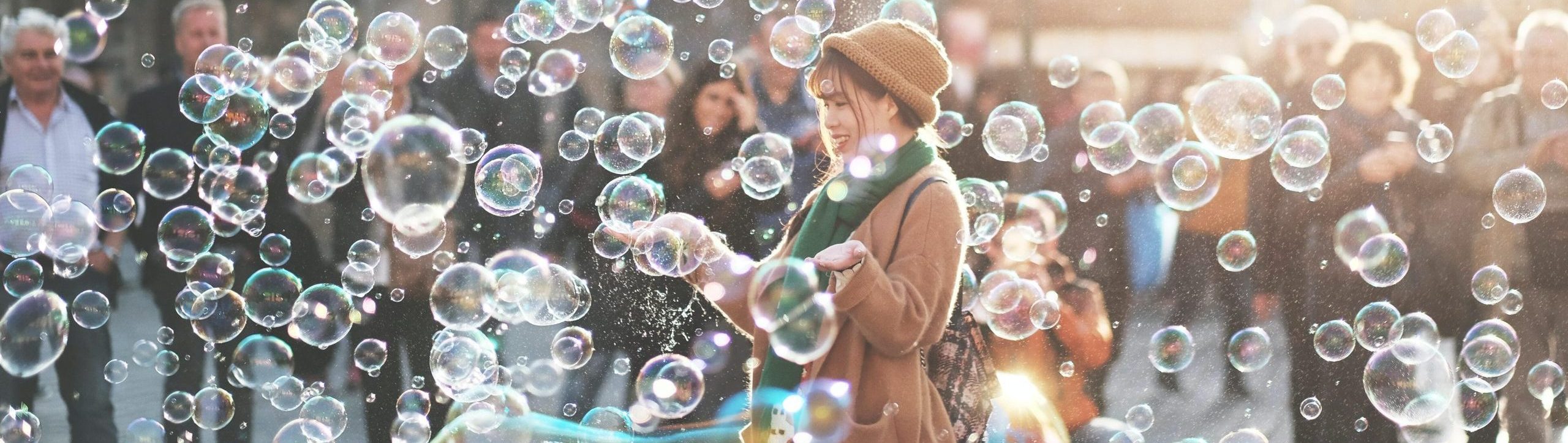 Young women in courtyard surrounded by bubbles