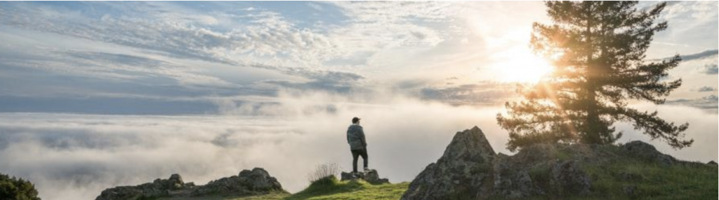 person on top of the mountain lookout above the clouds